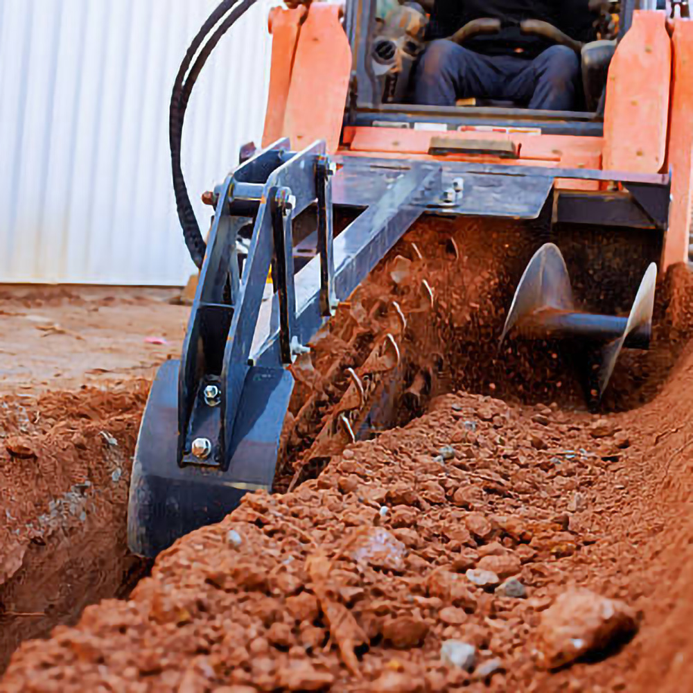 Close-up of a trenching machine digging into the ground, with soil being displaced.